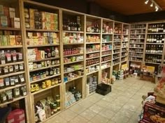 a store filled with lots of food and condiments on wooden shelves next to each other