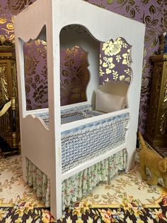 a doll house with a bed and dresser in the corner, next to a wallpapered wall