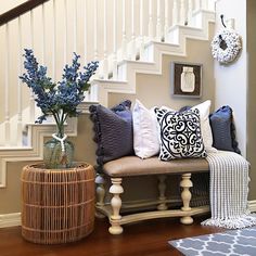 a set of stairs with pillows and vases on the floor next to it,