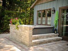 a hot tub sitting on top of a stone patio