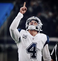 a close up of a person wearing a football uniform and pointing to the sideline