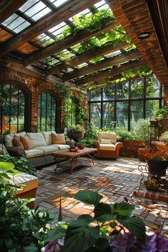 an outdoor living room with lots of plants and flowers on the floor in front of it