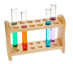 three test tubes filled with colored liquids on a wooden stand