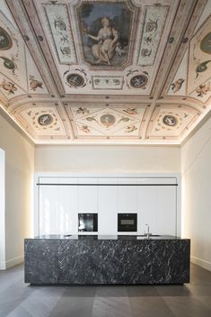 an empty room with marble counter tops and paintings on the ceiling