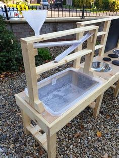 a wooden stand with two buckets on top of it and one in the middle