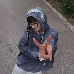 a young man wearing glasses and a hoodie making the vulcan sign with his hands