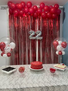 the table is set up with balloons and cake