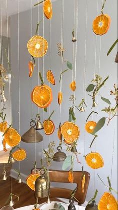 orange slices are hanging from strings on the ceiling in front of a dining room table