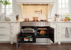 an open oven in a kitchen with pots and pans on the burners,