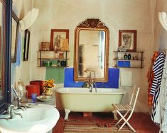 an old fashioned bathtub in the corner of a bathroom with a mirror above it