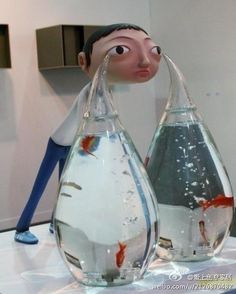 there are two fish in the vases on the table and one is upside down