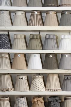 many different shades of lamps on shelves in a store