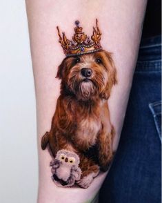 a dog with a crown on it's head sitting next to a small owl