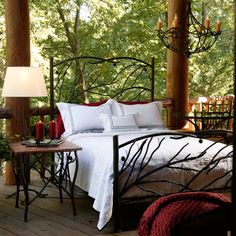 a bed sitting on top of a wooden floor next to a forest