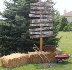 a wooden sign sitting next to a pile of hay