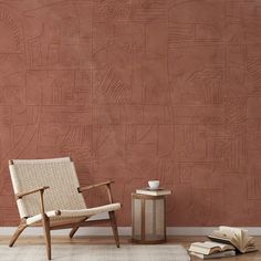 a chair sitting in front of a wall with a book on the floor next to it