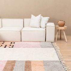 a white couch sitting on top of a hard wood floor next to a wooden table