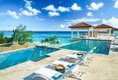 an outdoor swimming pool next to the ocean