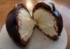 a half eaten chocolate covered doughnut sitting on top of a white plate