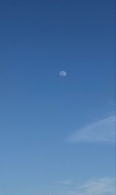 two people on the beach flying kites under a blue sky