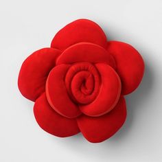 a large red flower sitting on top of a white surface