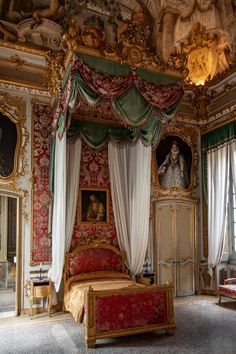 an ornately decorated bedroom with red and gold decor, including a canopy bed in the center