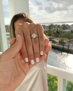 a man and woman holding each other's hand with their engagement ring in front of them