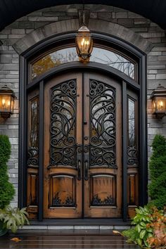 an ornate wooden door in front of a brick building with two lights on each side