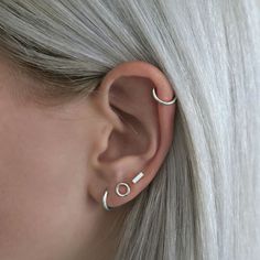 a woman with grey hair wearing an ear piercing