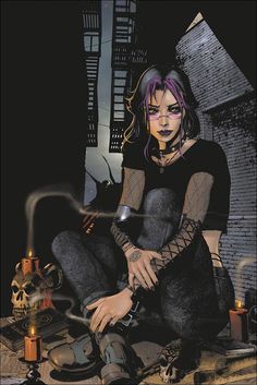 a woman with purple hair sitting on the ground next to a skull and candle holder