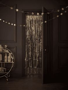 a black room with gold stars hanging from the ceiling and a round table in front of it