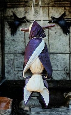 an ornament hanging from a rope with purple and white fabric wrapped around it