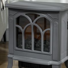 a small grey stove sitting on top of a hard wood floor