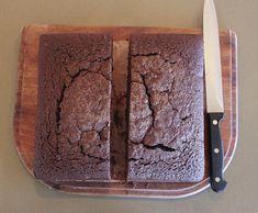 two slices of chocolate cake on a cutting board with a knife