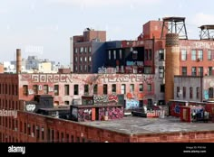 an old brick building with graffiti on it's side and other buildings in the background