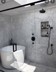 a white bath tub sitting inside of a bathroom next to a walk - in shower