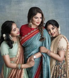 three women standing next to each other in sari