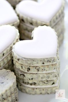 cookies with white frosting in the shape of a heart are stacked on top of each other