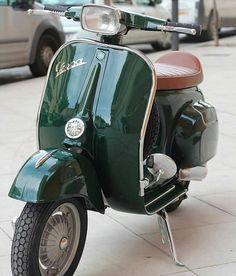 a green scooter is parked on the sidewalk