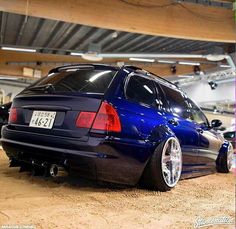 a blue car parked in a garage next to other cars