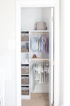 an open closet with clothes hanging on shelves