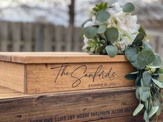 a wooden box with flowers on top of it