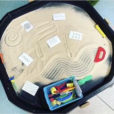 a sand tray with various toys on it