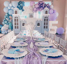 the table is set for a princess themed birthday party with balloons and paper plates on it