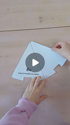 someone is cutting out a piece of paper to make an origami fish shape