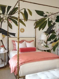 a white bed with pink and gold pillows