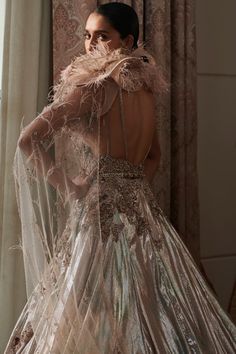 the back of a woman's dress with feathers on it