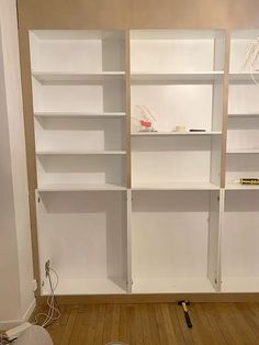 an empty room with white shelving and tools on the floor in front of it