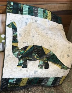 a quilted dinosaur sitting on top of a table