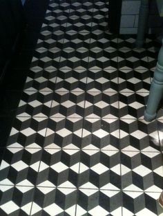 a black and white checkered tile floor in a restaurant or bar with an umbrella on it